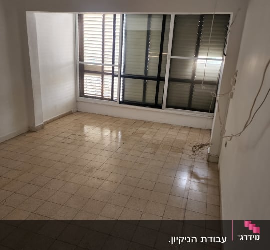 רצפה נקייה וחלון עם תריסים בחדר ריק